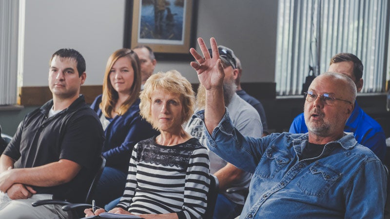 Group sitting one man raising hand