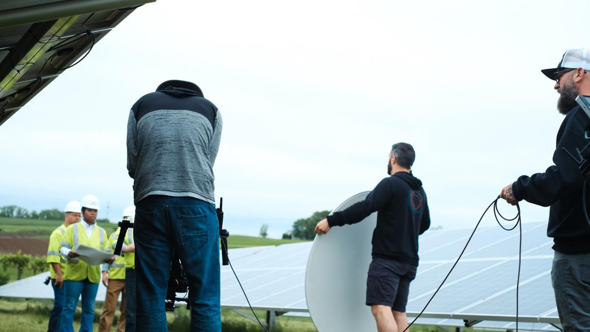 Film crew filming at a solar field
