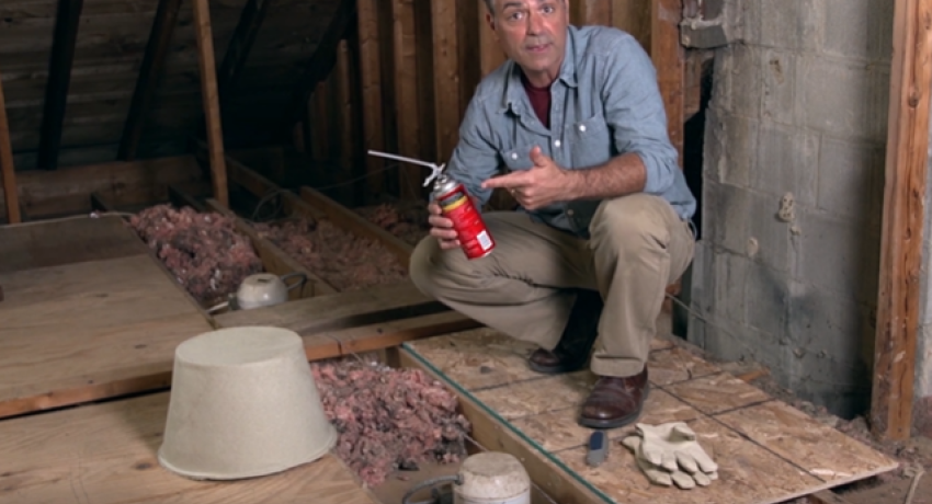 Man in attic holding spray can