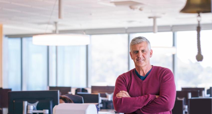 Man crossing arms and smiling in office