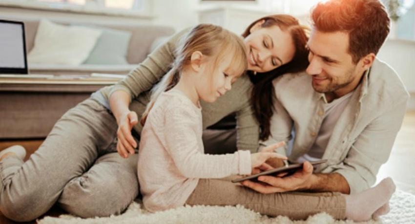 Woman and man next to little girl who is looking at ipad.