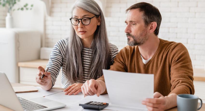 husband and wife paying bills together on laptop