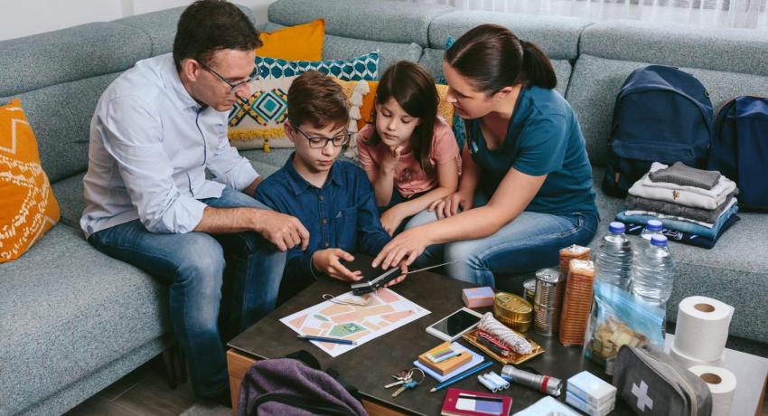 family on couch in living room all looking at a phone