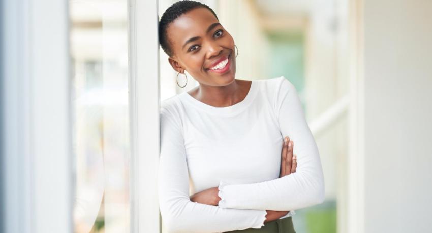 Woman smiling and leaning against window