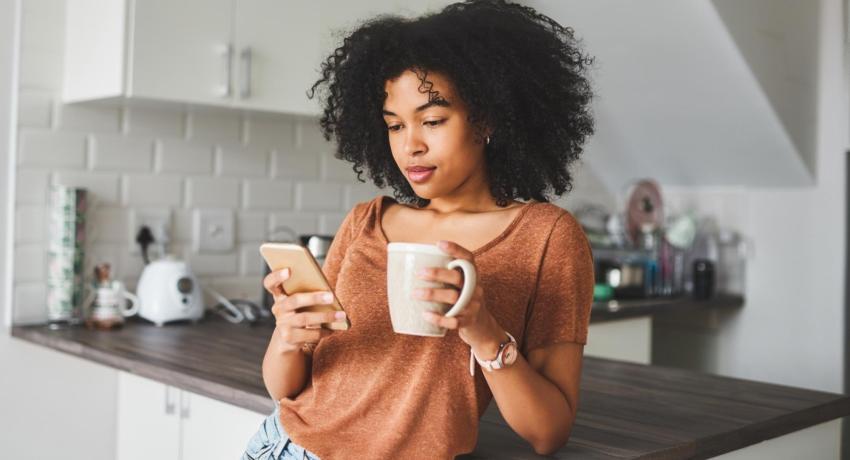 woman reading phone in kitchen