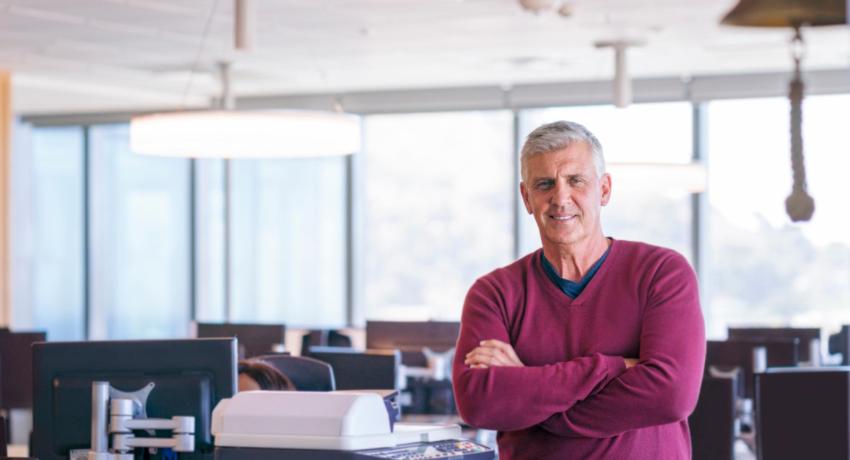 Man crossing arms and smiling in office