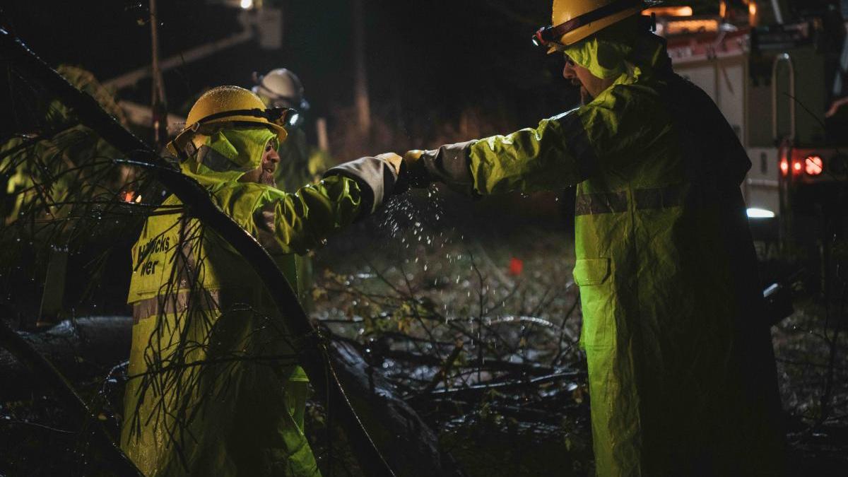 Two lineworkers fist bumping