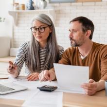 husband and wife paying bills together on laptop