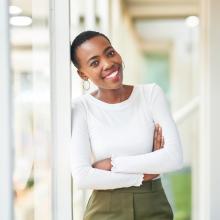 Woman smiling and leaning against window