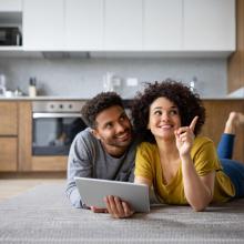 Couple planning a remodel on laptop on floor