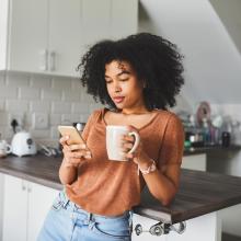 woman reading phone in kitchen