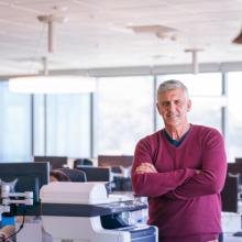 Man crossing arms and smiling in office